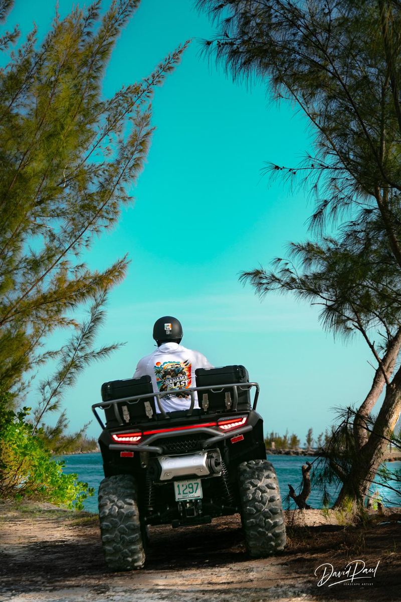 Rider in a Bahama Blast shirt looking out at turquoise water