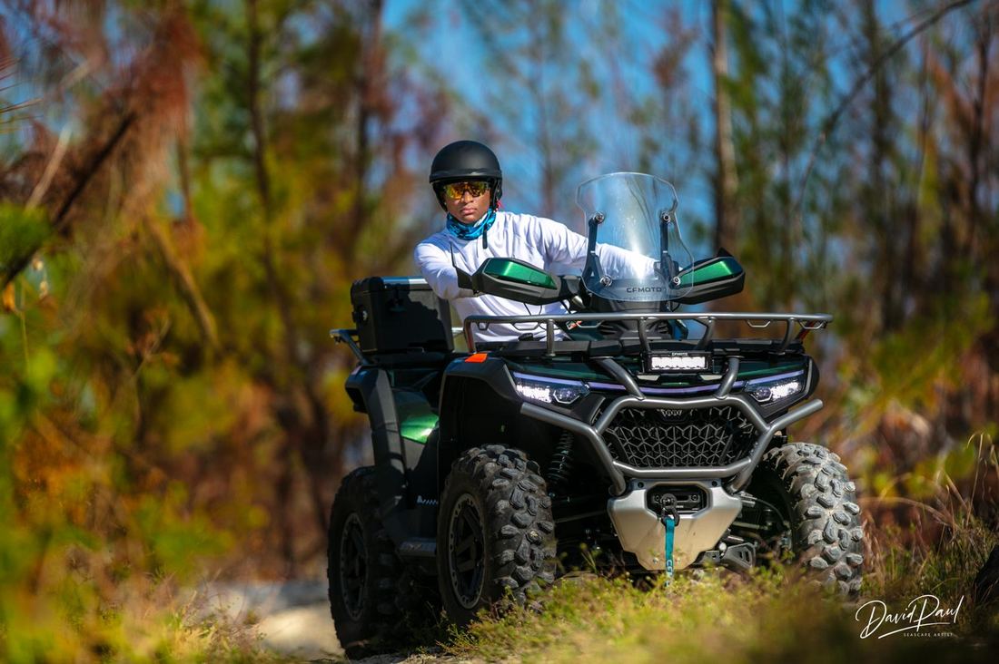 Rider on a green ATV on a trail
